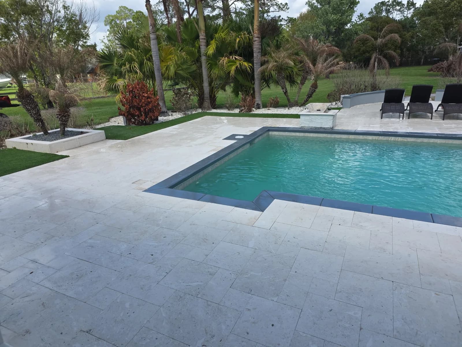 Custom pool deck with travertine pavers and coping