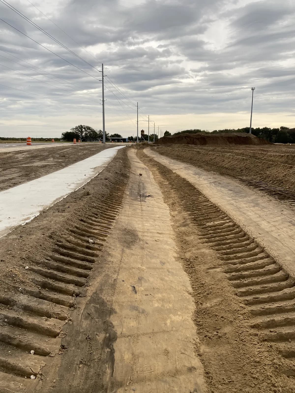 Freshly graded swale beside a new sidewalk